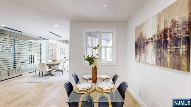 dining room featuring visible vents, baseboards, and wood finished floors