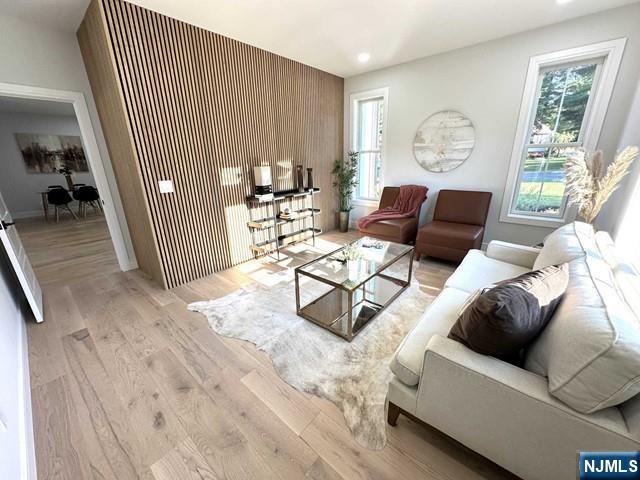 living area with recessed lighting, baseboards, and light wood finished floors