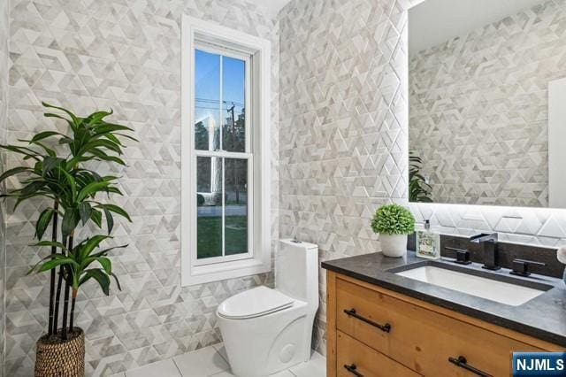 bathroom featuring toilet, tile walls, vanity, and tile patterned floors