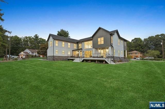 back of house featuring a lawn and board and batten siding