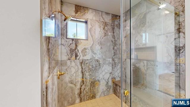 full bathroom with a marble finish shower