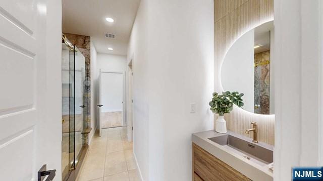 hall with recessed lighting, visible vents, a sink, and light tile patterned flooring