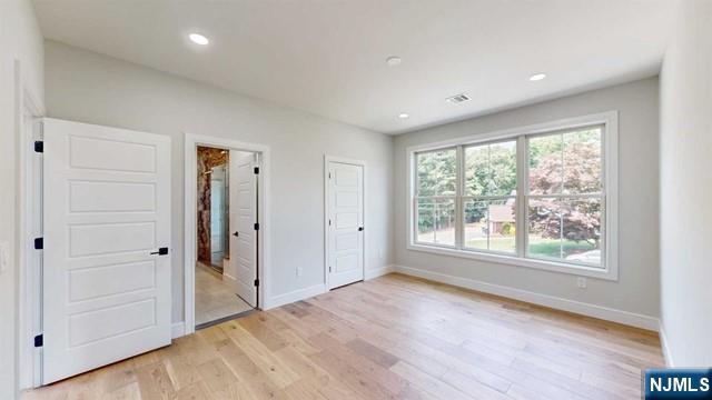 unfurnished bedroom featuring recessed lighting, light wood-style flooring, and baseboards