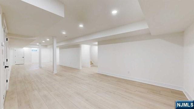 finished below grade area with baseboards, light wood-style flooring, and recessed lighting