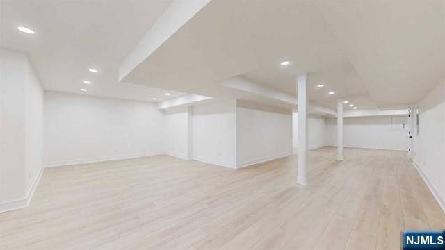 finished below grade area featuring baseboards, recessed lighting, and light wood-style floors