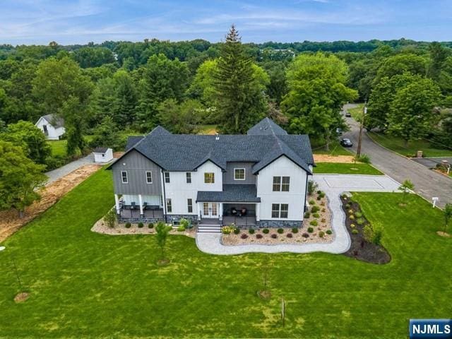 birds eye view of property featuring a wooded view