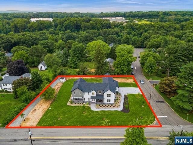 birds eye view of property featuring a forest view