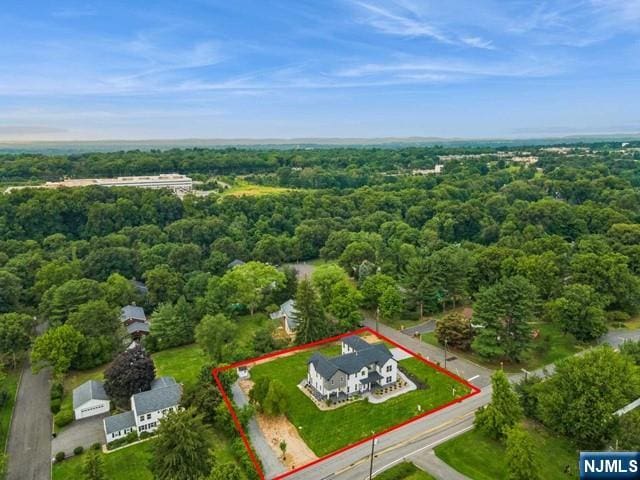 birds eye view of property with a view of trees