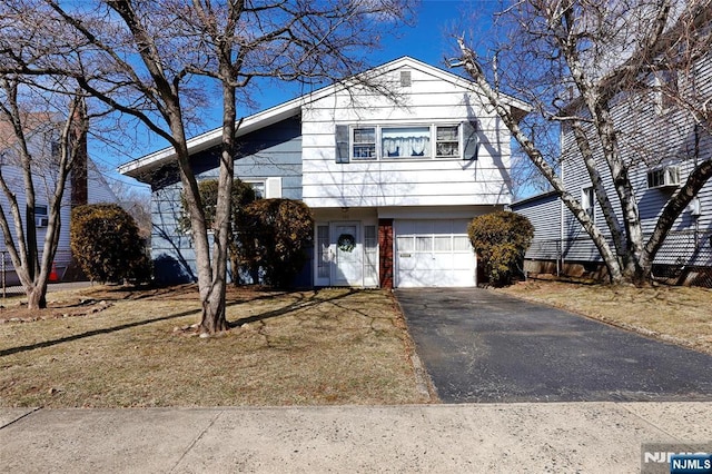 tri-level home with aphalt driveway, brick siding, and an attached garage