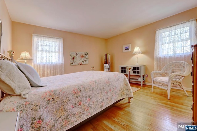 bedroom with light wood-style flooring and baseboards