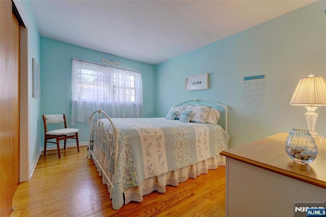 bedroom featuring light wood finished floors and baseboards