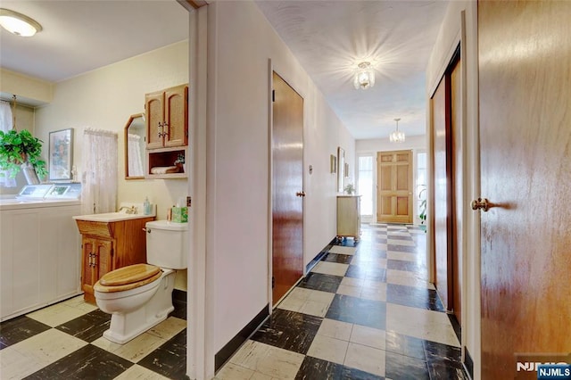 hall with baseboards, washing machine and clothes dryer, and tile patterned floors