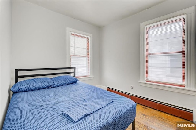 bedroom featuring a baseboard radiator and wood-type flooring