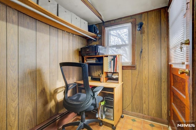 home office featuring light tile patterned floors and wood walls