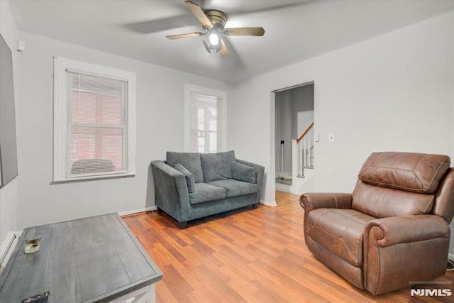 living room with ceiling fan and light hardwood / wood-style flooring