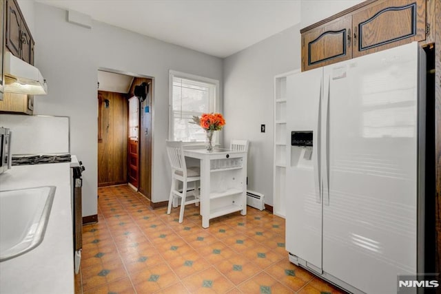 kitchen with dark brown cabinetry, white refrigerator with ice dispenser, sink, and a baseboard heating unit