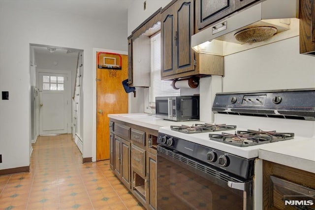 kitchen featuring dark brown cabinetry, white range with gas cooktop, and sink