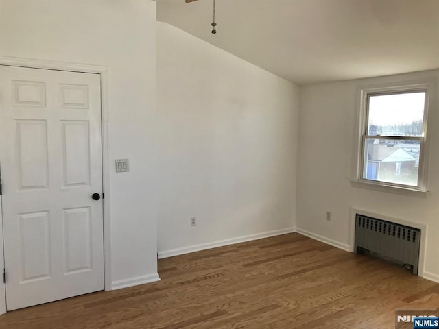 empty room featuring hardwood / wood-style flooring and radiator