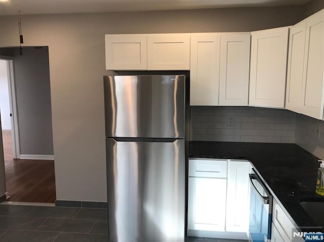 kitchen featuring backsplash, stainless steel fridge, dishwasher, and white cabinets