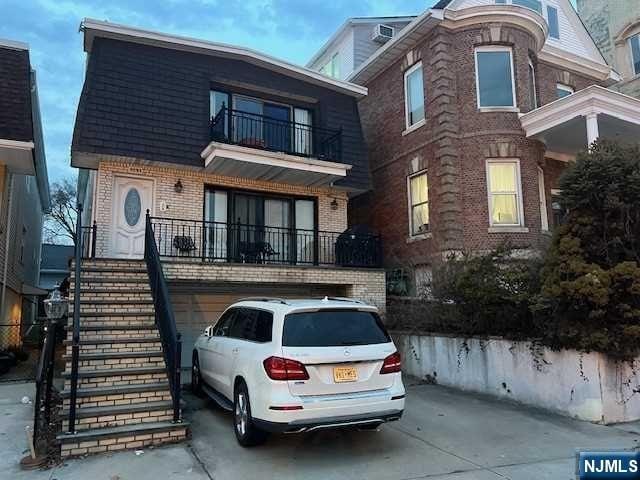 view of front of house featuring a garage and a balcony