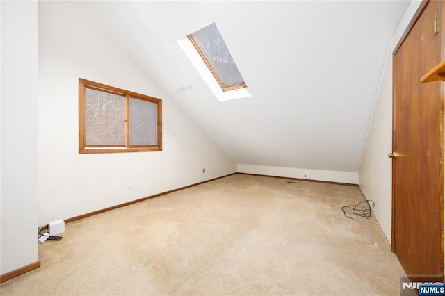 bonus room with lofted ceiling with skylight and light carpet