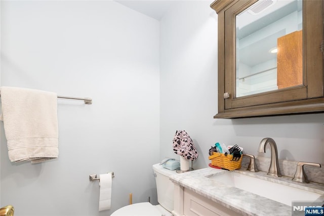 bathroom featuring vanity and toilet