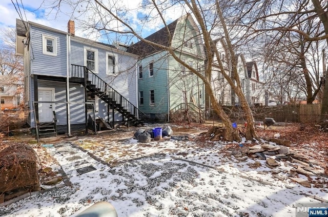 view of snow covered rear of property