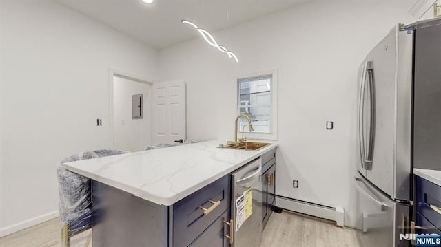 kitchen featuring light wood-type flooring, sink, a baseboard radiator, and appliances with stainless steel finishes