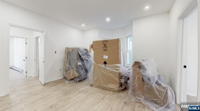 misc room with light hardwood / wood-style flooring and a baseboard heating unit