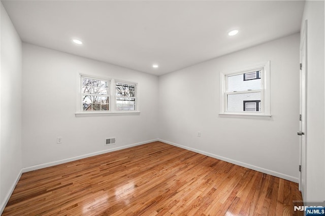 spare room with plenty of natural light and light hardwood / wood-style floors