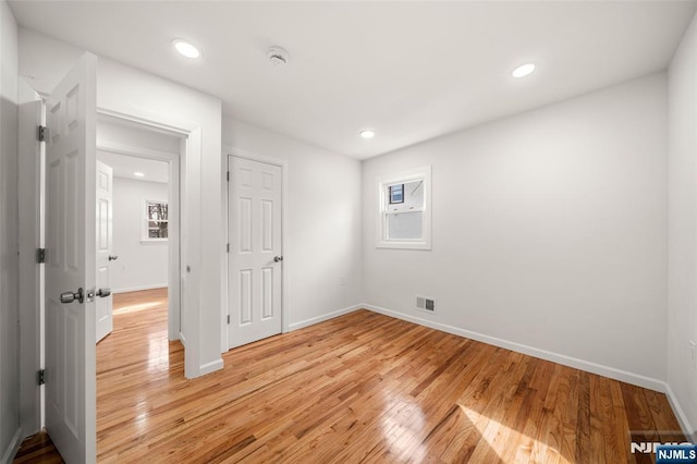 spare room featuring a healthy amount of sunlight and light wood-type flooring