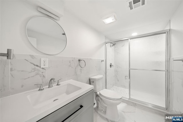 bathroom featuring vanity, toilet, tile walls, and walk in shower