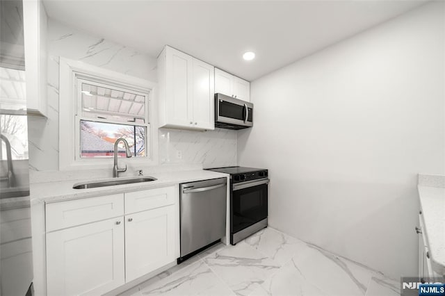 kitchen featuring appliances with stainless steel finishes, sink, and white cabinets