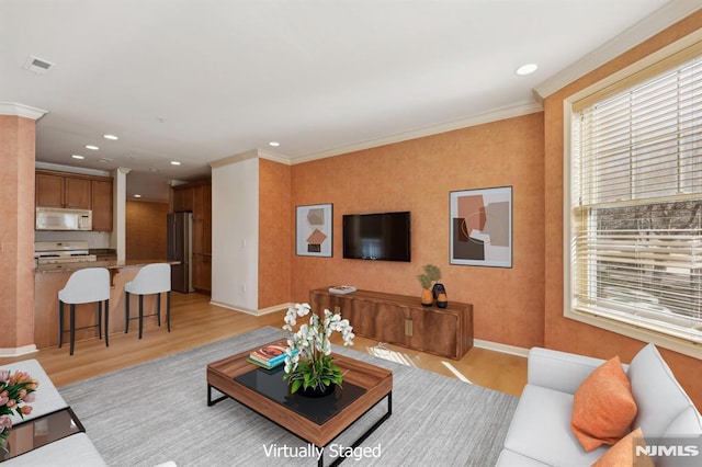 living room with crown molding and light wood-type flooring