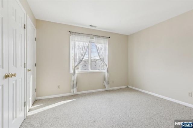 unfurnished bedroom with visible vents, light carpet, and baseboards