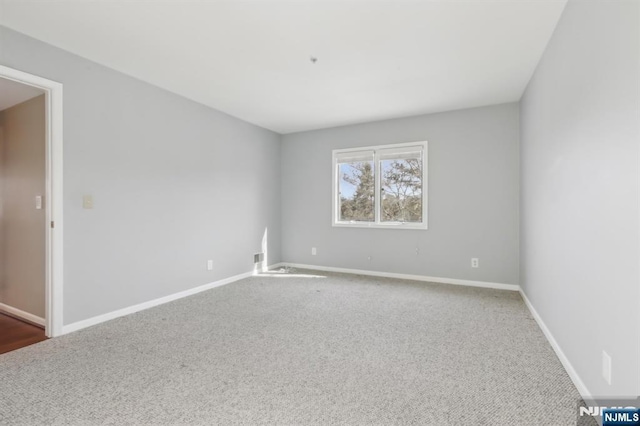 carpeted empty room with baseboards