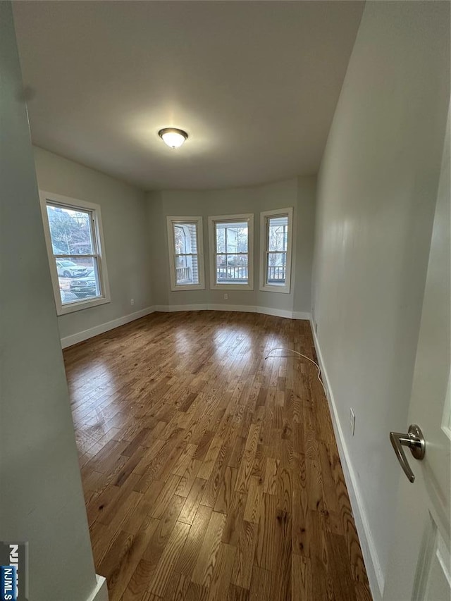 unfurnished room with hardwood / wood-style flooring