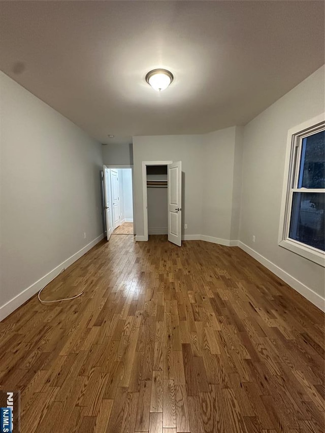 unfurnished bedroom featuring hardwood / wood-style floors and a closet