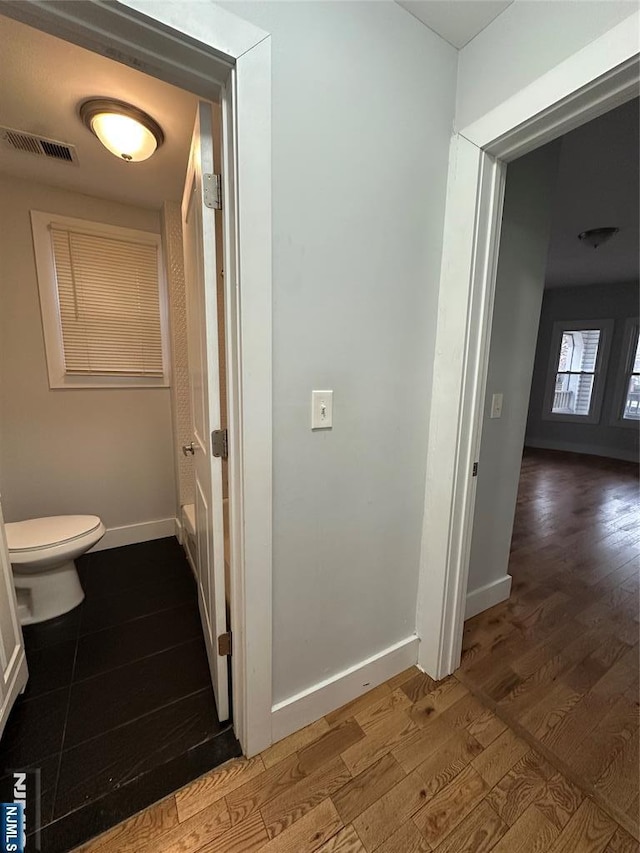 bathroom featuring wood-type flooring and toilet