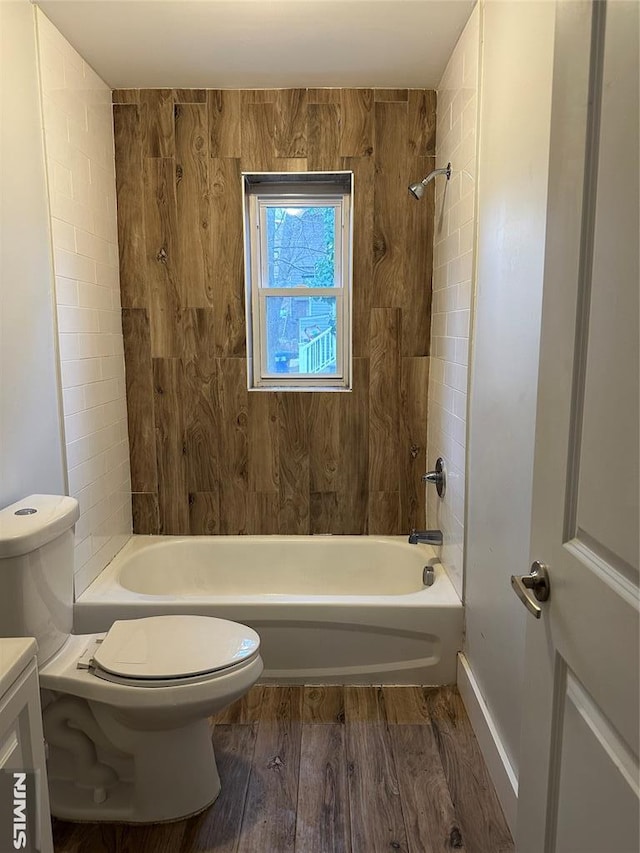 full bathroom with hardwood / wood-style flooring, tiled shower / bath, vanity, and toilet