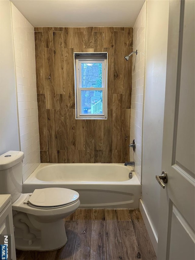 full bathroom with hardwood / wood-style flooring, vanity, tiled shower / bath combo, and toilet