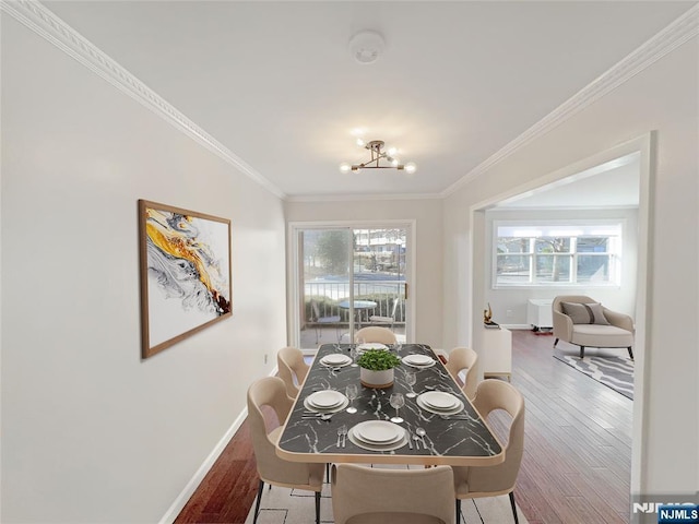 dining room with ornamental molding, plenty of natural light, and wood-type flooring