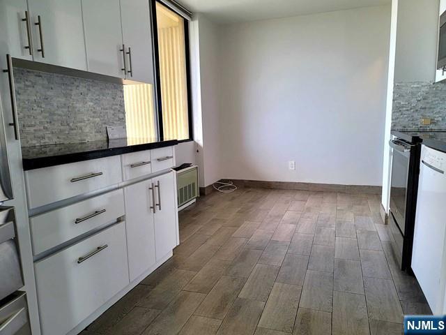 kitchen featuring tasteful backsplash, electric range, dark hardwood / wood-style flooring, and white cabinets