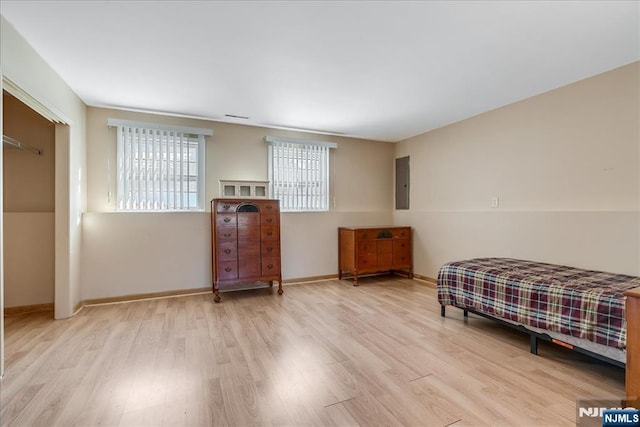 bedroom with electric panel and light hardwood / wood-style flooring