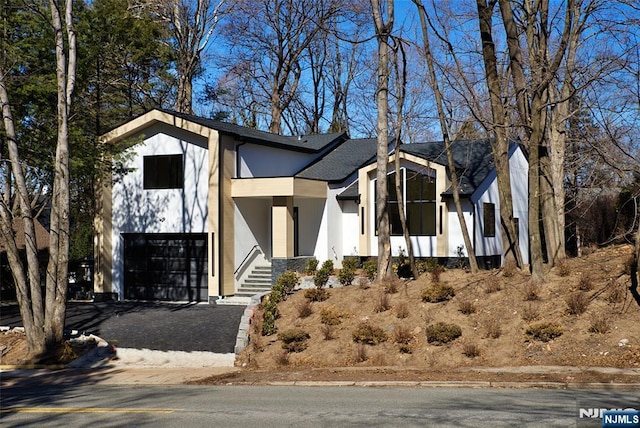 view of front facade with driveway, an attached garage, and stucco siding