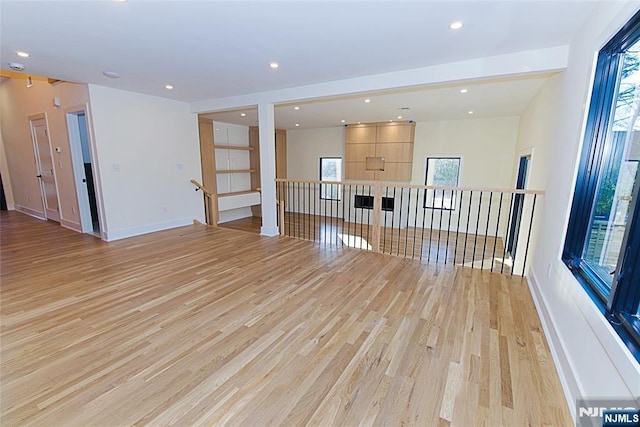 empty room featuring light wood-type flooring, baseboards, and recessed lighting