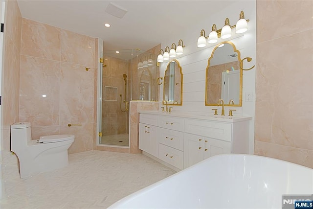 full bath featuring a freestanding tub, a sink, tile walls, a shower stall, and double vanity