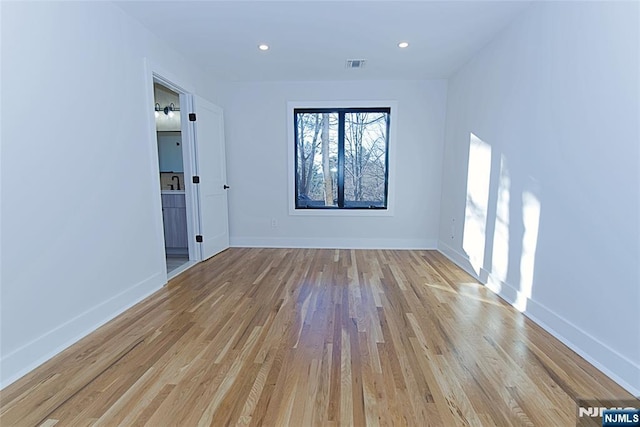 empty room featuring recessed lighting, visible vents, light wood-style flooring, and baseboards