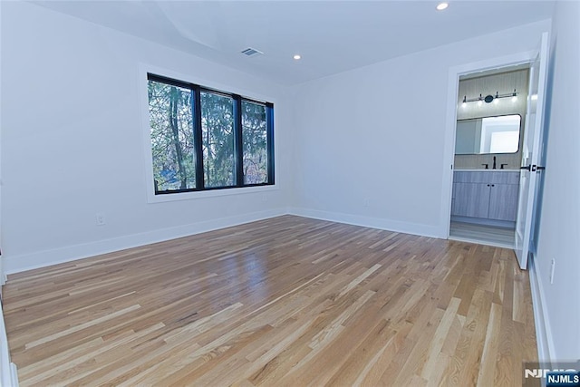 unfurnished room with light wood finished floors, visible vents, baseboards, and recessed lighting