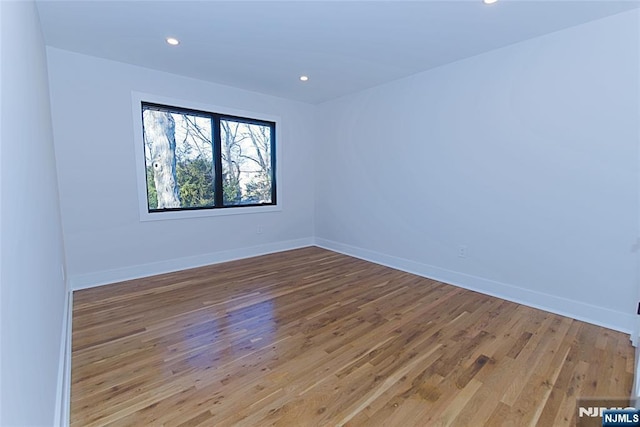 unfurnished room featuring recessed lighting, baseboards, and wood finished floors